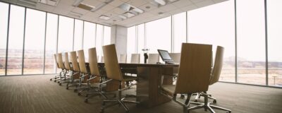 A fish eye view of a an empty fancy meeting room with chairs perfectly aligned.