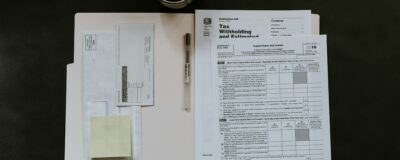 Top view of black table with open manila envelope with tax documents inside