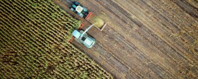Top view of farm equipment harvesting crops in a field